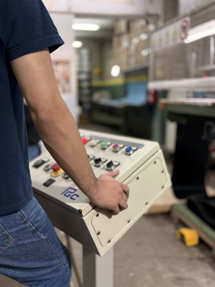Técnico operando panel de control de máquina cortadora de bandas — Warbel S.A.